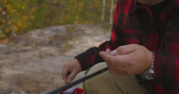 Pêcheur choisit et fixe appâts et leurres sur crochet de tige, vue rapprochée des mains, l'homme pêche à la ligne — Video