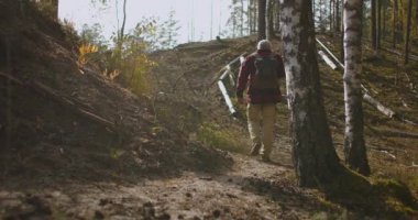 Yalnız orta yaşlı bir adam ormanda yürüyüş yapıyor, Sırt çantası taşıyor, insan ve doğa, sonbahar günü ormanda