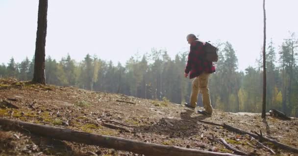 Plecak i ciesząc się pięknem natury w jesienny dzień, mężczyzna w średnim wieku wędruje i rośnie na szczycie wzgórza, rozglądając się dookoła — Wideo stockowe