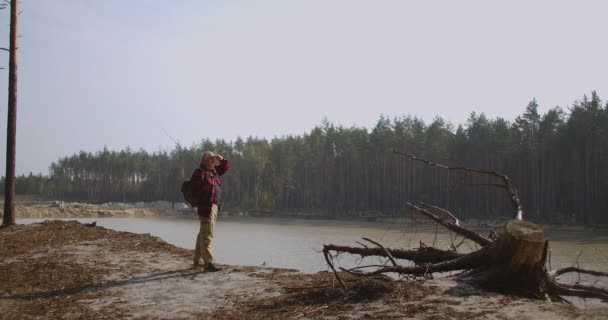 Fischer schaut sich am Waldsee um, bewundert die Natur in der Herbstsaison, angelt und entspannt — Stockvideo