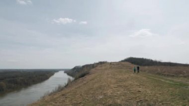 Genç çift el ele tutuşarak Nehri yakınlarındaki tepe geçer