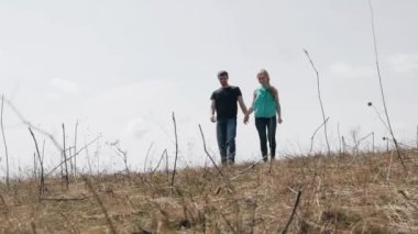 Genç çift elele bir alanda yürüyüş