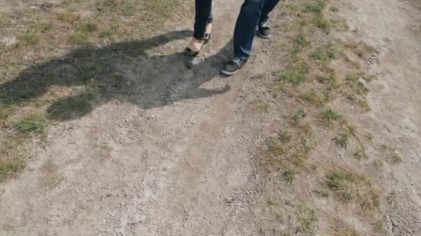 Turistické lidí - boty zblízka a naklánět. Mladí lidé pár chodící polní cestu. — Stock video