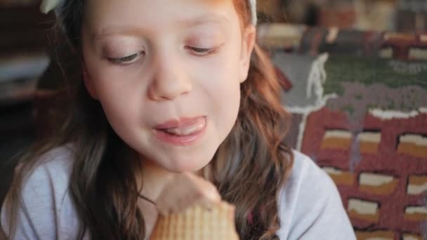 Девушка в кафе ест мороженое — стоковое видео