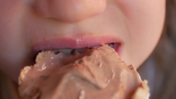 Mond van de baby bijt close-up van chocolade-ijs. — Stockvideo