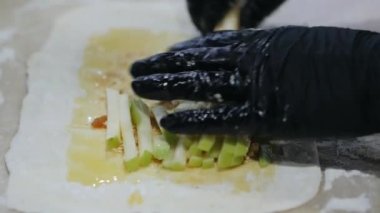 Eldivenli eller, hamur üzerinde Apple meyveli turta ve fırın ürünleri için taze meyve serer. Fındık, kuru üzüm, dolgu