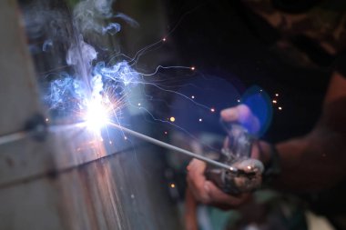 Tel ve metal ile duman yangın ve pırıltılı ışık kaynak tepkisi, işçiler elinde kaynak olan.