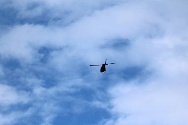 Mavi gökyüzü ile uçuş sırasında uçan bir siyah helikopter uçak 