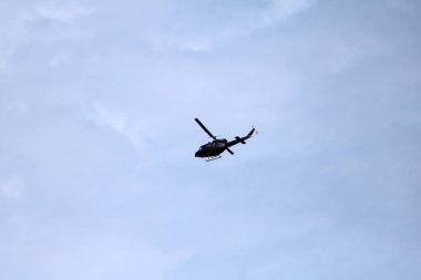 Mavi gökyüzü ile uçuş sırasında uçan bir siyah helikopter uçak 