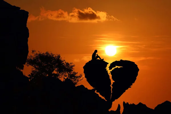 赤い空の夕焼けと山の上の傷ついた心形岩のカップルします シルエット バレンタイン背景コンセプト — ストック写真