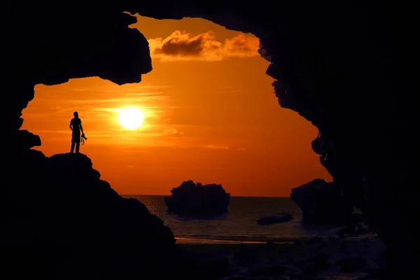 Fotógrafo Pie Sobre Roca Cueva Cerca Playa Atardecer Cielo Rojo —  Fotos de Stock