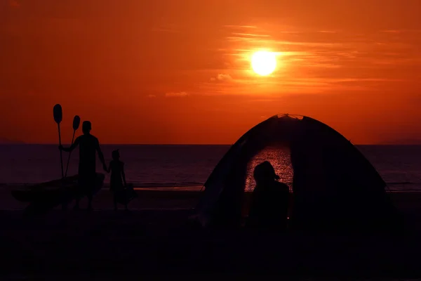 Silhouette camping familial et kayak sur la plage avec ciel rouge — Photo