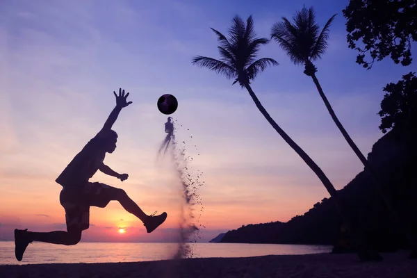 Aziatisch mens voetballen op het strand bij zonsopgang vroege ochtend. — Stockfoto