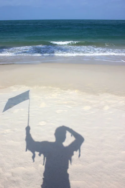 De schaduw van de Wanderer houdt de vlag op de woestijn — Stockfoto