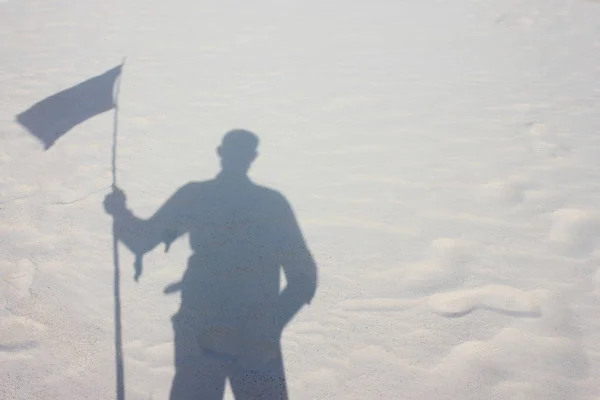 Тінь мандрівник тримають прапор на пустині — стокове фото