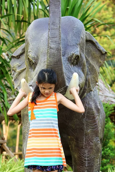 Asian girl enjoying with elephant statue in the Public park gard — Stock Photo, Image