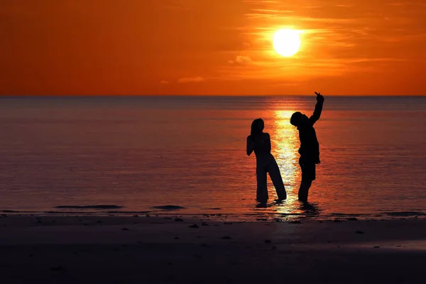 Silhouet van Aziatische koppels genieten tijdens zonsondergang op de b — Stockfoto