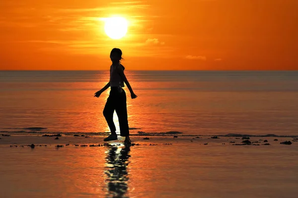 Silhouet van één Aziatisch meisje genieten van zichzelf tijdens zonsondergang o — Stockfoto