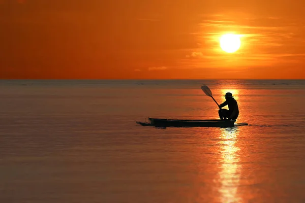Silhouette de pêcheurs locaux ramant de petits bateaux le long de la côte — Photo