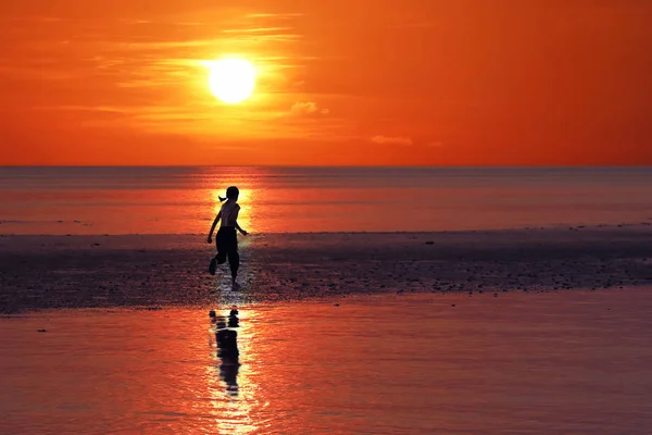 Silhouet van één Aziatisch meisje genieten van zichzelf tijdens zonsondergang o — Stockfoto