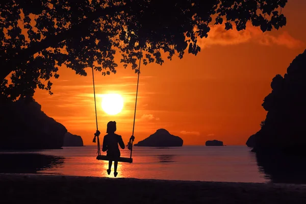 Silhouette d'une fille assise sur une balançoire ou un berceau sur la plage a — Photo