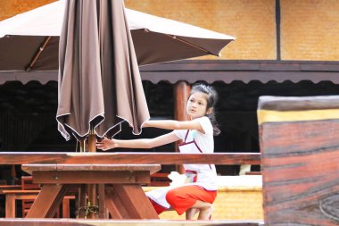 Kız büyük bir şemsiye çekiyordu. R'de çalışan çocuklar