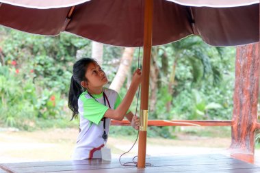 Kız büyük bir şemsiye çekiyordu. R'de çalışan çocuklar