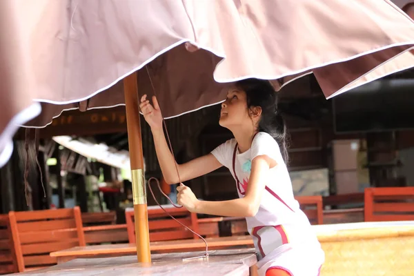 Asian girl raise an umbrella, Students or Children working in th — Stock Photo, Image