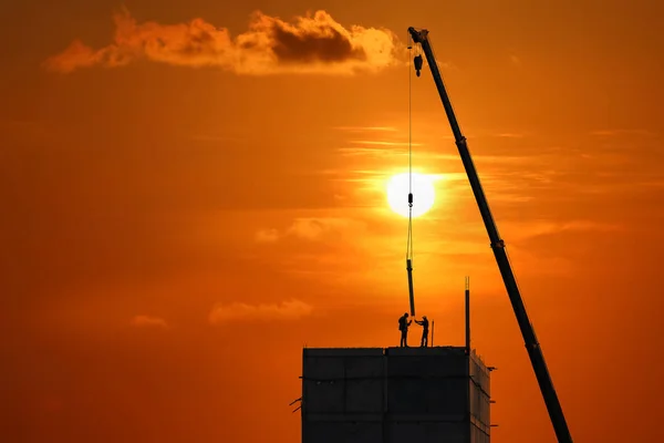 Pracownicy budowlani pracują na szczycie budynku — Zdjęcie stockowe