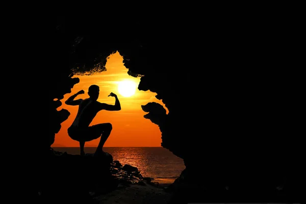 Postura o acción del cavernícola en la cueva al atardecer —  Fotos de Stock