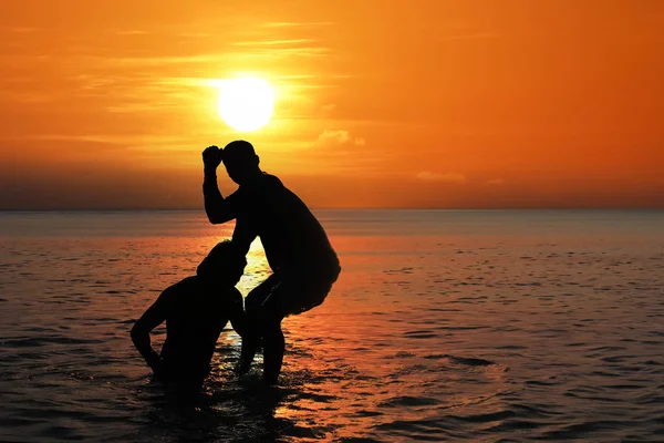 Asiatisk man öva thaiboxning på havet stranden vid solnedgången — Stockfoto
