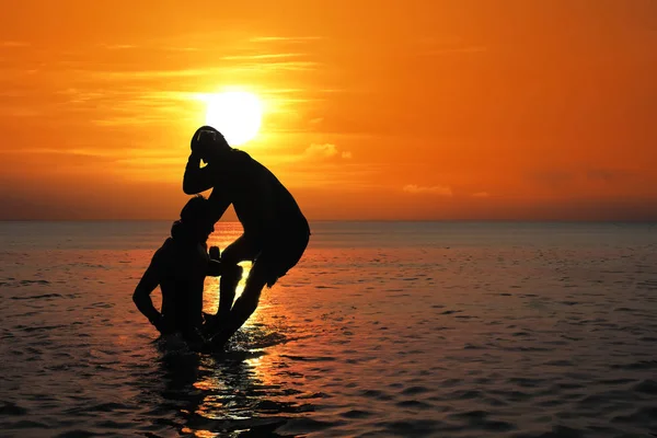 Aziatische man beoefenen van Thais Boksen op het strand van de zee bij zonsondergang — Stockfoto