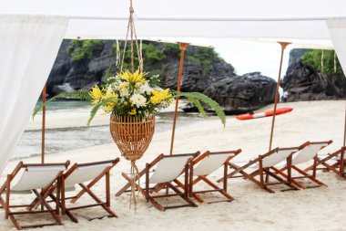 Tropik adada sahilde beyaz şemsiyeli sandalyeler