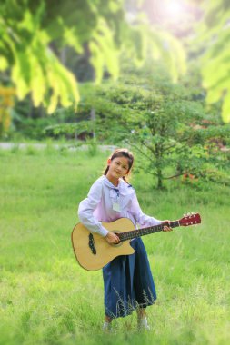 Asyalı okul kız çim gitar çalıyor , Öğrenci öğrenmek