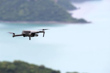 Gökyüzünde uçarken drone' lar, Okyanus ve ada arka planlar.
