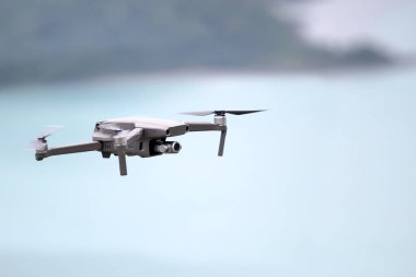 Gökyüzünde uçarken drone' lar, Okyanus ve ada arka planlar.