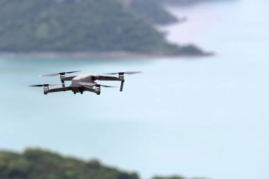 Gökyüzünde uçarken drone' lar, Okyanus ve ada arka planlar.