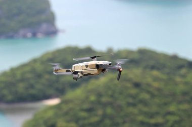 Gökyüzünde uçarken drone' lar, Okyanus ve ada arka planlar.