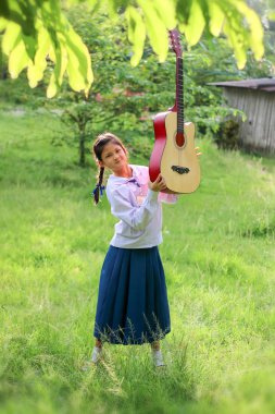 Asyalı okul kız çim gitar çalıyor , Öğrenci öğrenmek