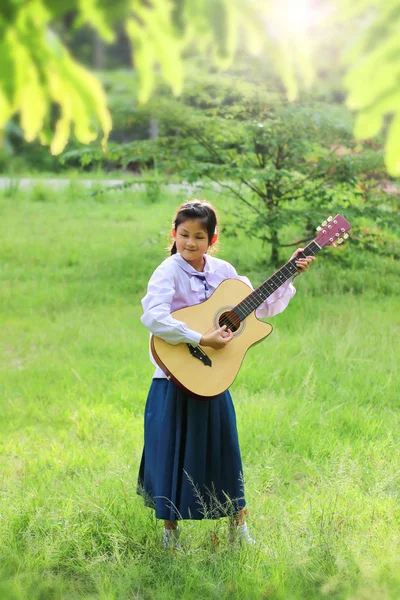 Asyalı okul kız çim gitar çalıyor , Öğrenci öğrenmek