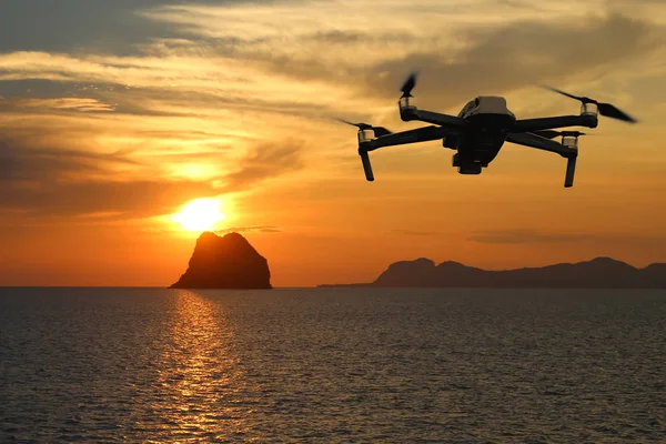 Drones mientras vuelan en el cielo al atardecer, el océano y la isla backg —  Fotos de Stock
