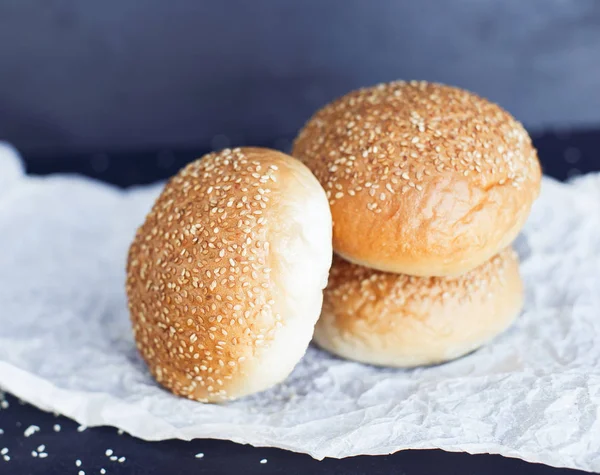 Parşömen kağıdı üzerinde üç taze çörek — Stok fotoğraf