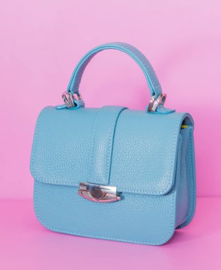 Pembe arka plan üzerinde mavi çanta