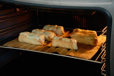 Sabah kahvaltısı: sıcak fırında hamurla kaplı sosisler. Lezzetli ve taze hamur işi. Lezzetli kahvaltı mı yoksa ev yapımı öğle yemeği mi?.