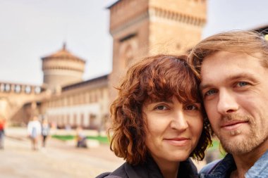 Avrupa şatosunun arka planında selfie çeken güzel pozitif turistler, güneşli sonbahar renkleri, romantik havası. Seyahat, mutluluk ve yaşam tarzı kavramları.