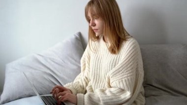 Dizüstü bilgisayarlı kazaklı genç bir iş kadını ya da ofisten iş arkadaşlarıyla mesajlaşıyor. Çevrimiçi öğrenim, çalışma, gezinme, kablosuz internet, teknoloji konsepti