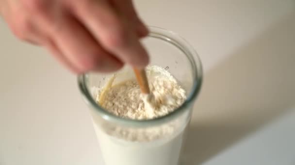 Närbild Hand Blanda Golvet Mjölken Med Träsked Ett Glas Koncept — Stockvideo
