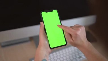 Akıllı telefon kullanan, internetten alışveriş yapan, cep telefonundan yeşil ekranı izleyen, internetten krom anahtar taraması yapan, izleyen, sosyal medya okuyan bir iş kadını. Bilgisayar arkaplanı olan elleri kapat