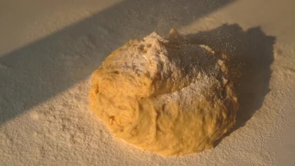 在揉搓的过程中 在阳光灿烂的厨房桌子上把面粉筛到面团上 厨师正在厨房里做面包面团 把面粉筛到面团上 烹调或烘焙概念 — 图库视频影像