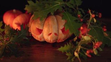 Cadılar Bayramı oyulmuş balkabağı. Balkabağı süslemesi sonbahar Azizler Günü için yanan mumla aydınlatılıyor. Korkunç Jack O 'Lantern suratı. 4K görüntü.